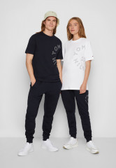 Tommy Hilfiger ROUNDALL GRAPHIC SWEATPANT UNISEX Tracksuit bottoms desert sky СПОРТИВНЫЕ БРЮКИ ROUNDALL GRAPHIC UNISEX Спортивные штаны небо пустыни