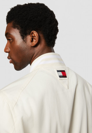 Tommy Hilfiger TOMMY HILFIGER X SHAWN MENDES COTTON VARSITY BOMBER EXCLUSIVE UNISEX Bomber Jacket weathered white TOMMY HILFIGER X SHAWN MENDES ХЛОПКОВАЯ КУРТКА-БОМБЕР ЭКСКЛЮЗИВ УНИСЕКС Куртка-бомбер выветрившийся белый