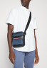 Tommy Hilfiger 1985 MINI REPORTER UNISEX Across body bag desert sky 1985 MINI REPORTER UNISEX — Сумка через плечо небо пустыни